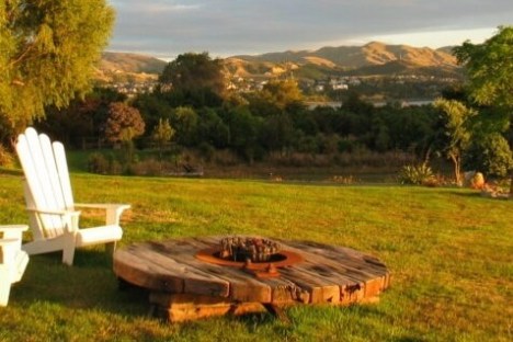 a couple of lawn chairs sitting on top of a lush green field