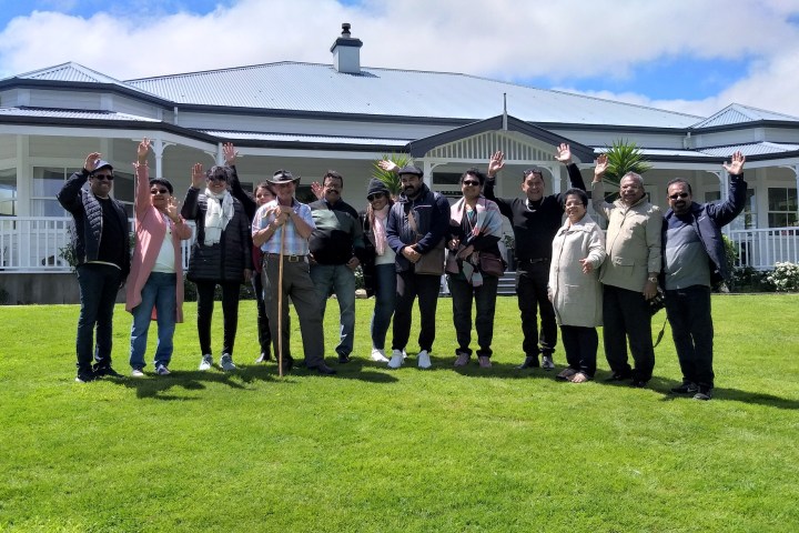 a group of people standing in a grass field posing for the camera