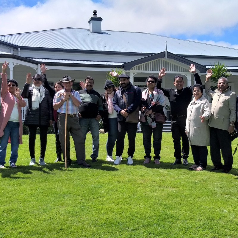 a group of people standing in a grass field posing for the camera